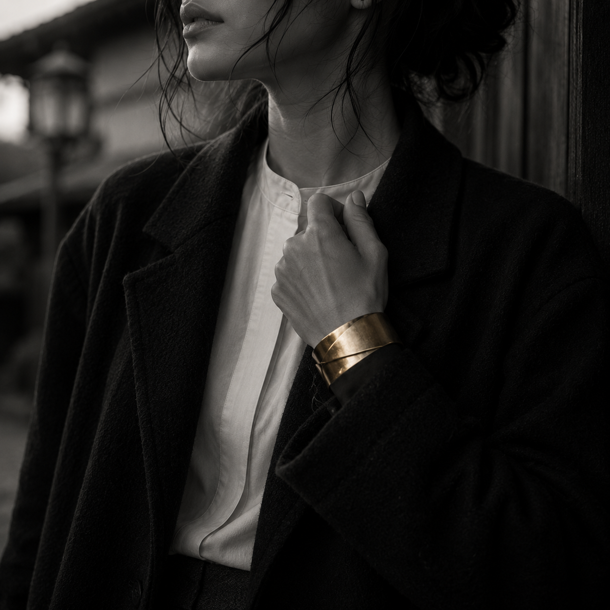 Close detail of gold cuff and black tailoring